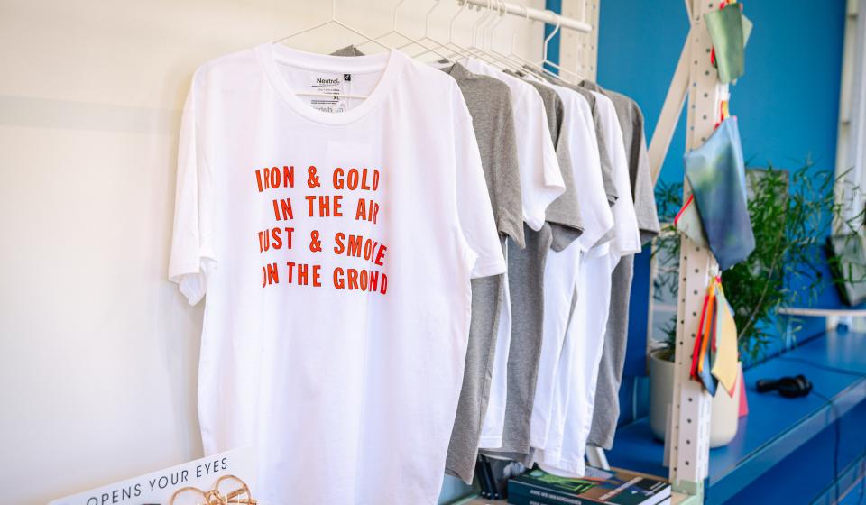 Wit T-shirt met rood opschrift RON & GOLD IN THE AIR DUST & SMOKE ON THE GROUND