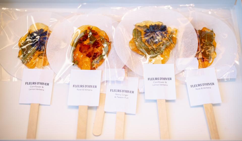 Vijftal bloementhee infusies op houten stick naast elkaar gepresenteerd